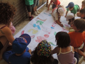 Els nens pinten una pancarta del Casal del Mediterrani.
